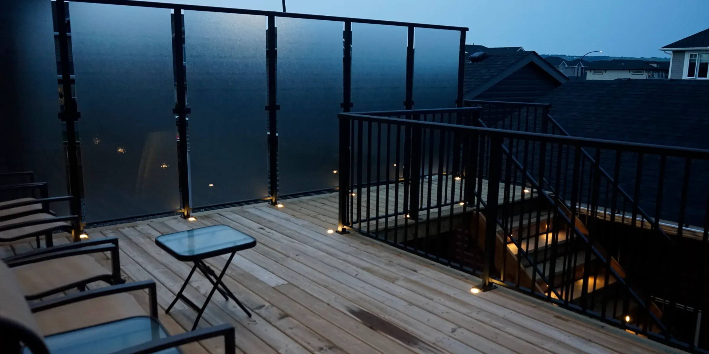 Raised deck with glass railing and small lights in the boards