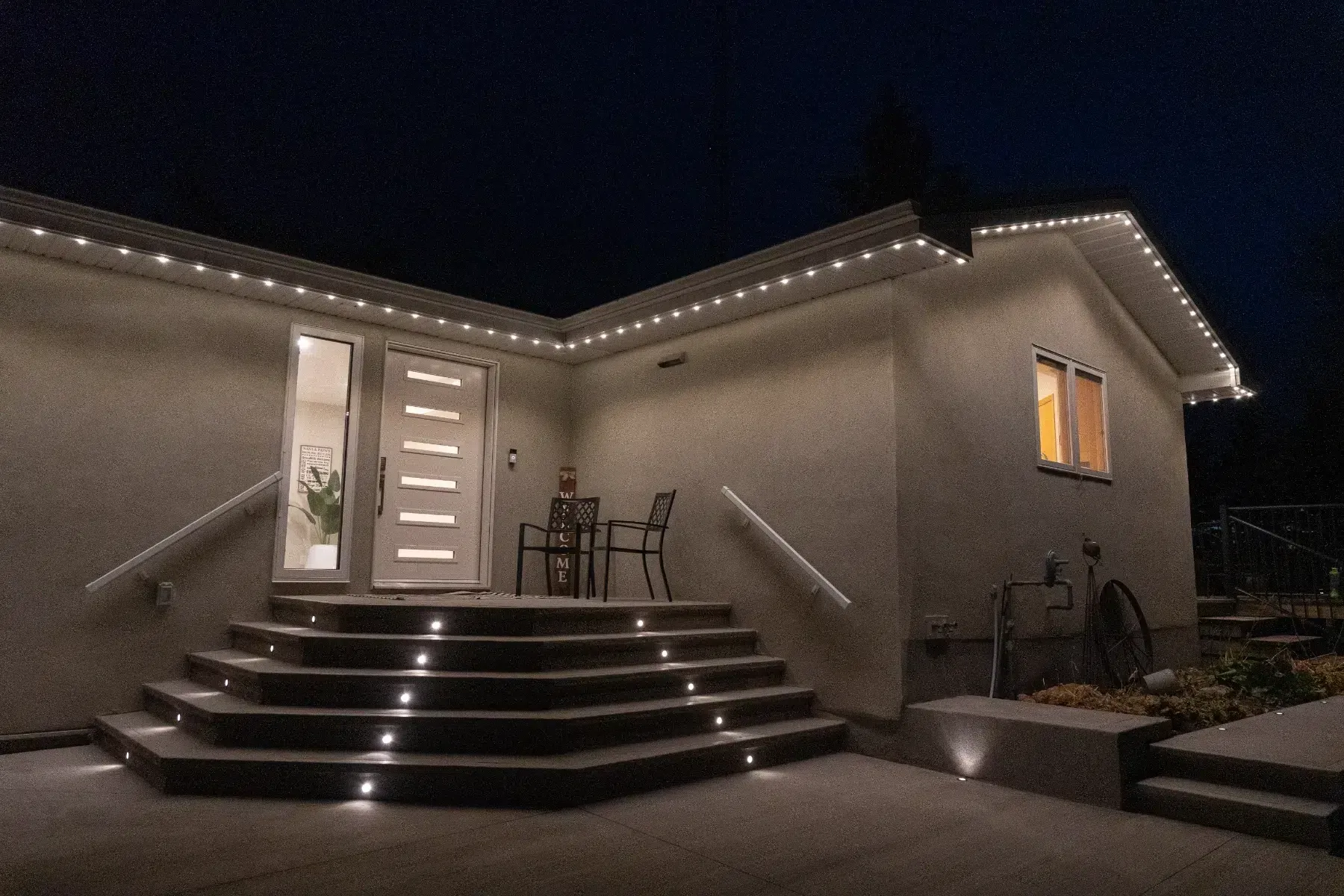 Stairs to a stucco house with white lights in each step
