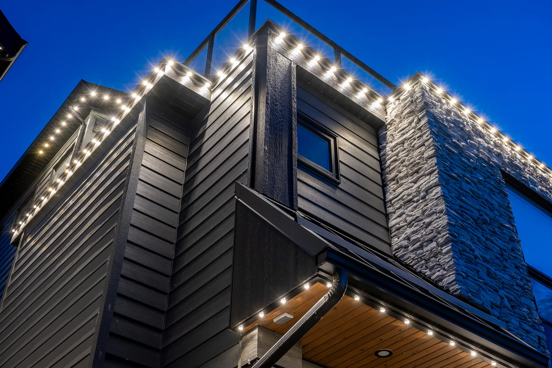 Dark modern house with cool white roofline lights