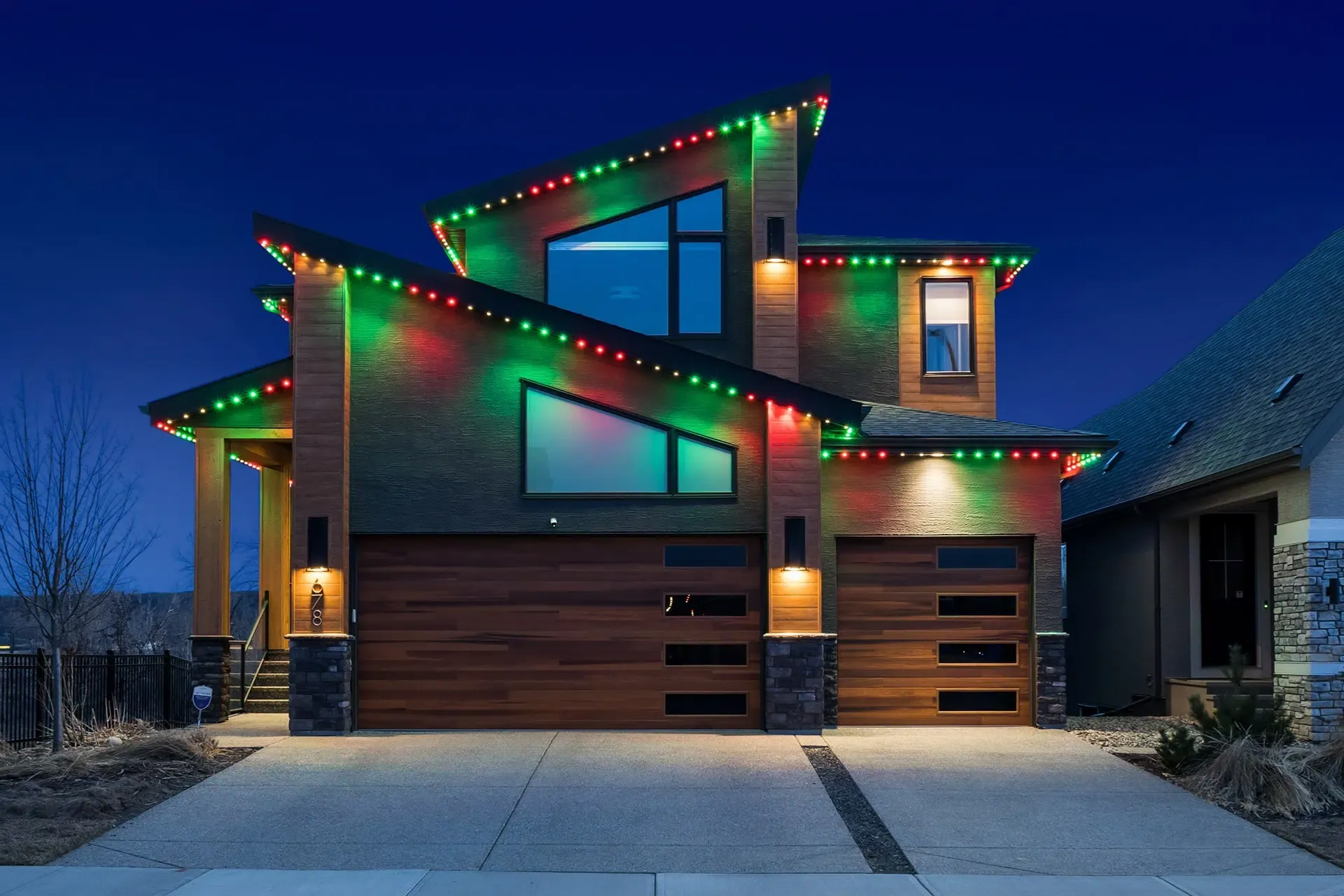 Modern house at blue hour with red and green roofline lights