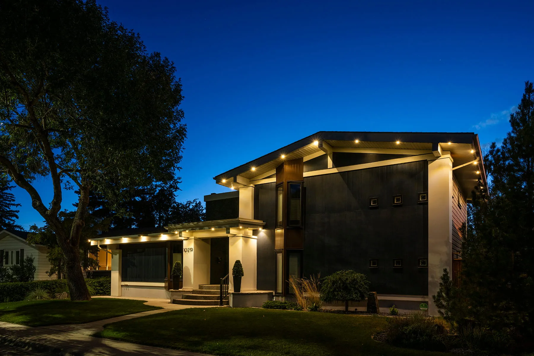 Modern two-storey home in warm white at blue hour